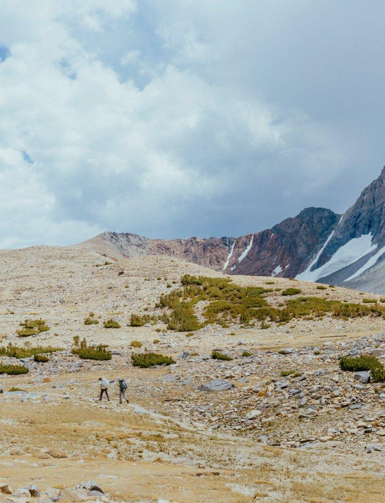 Two climbers hike on their approach in the mountains.