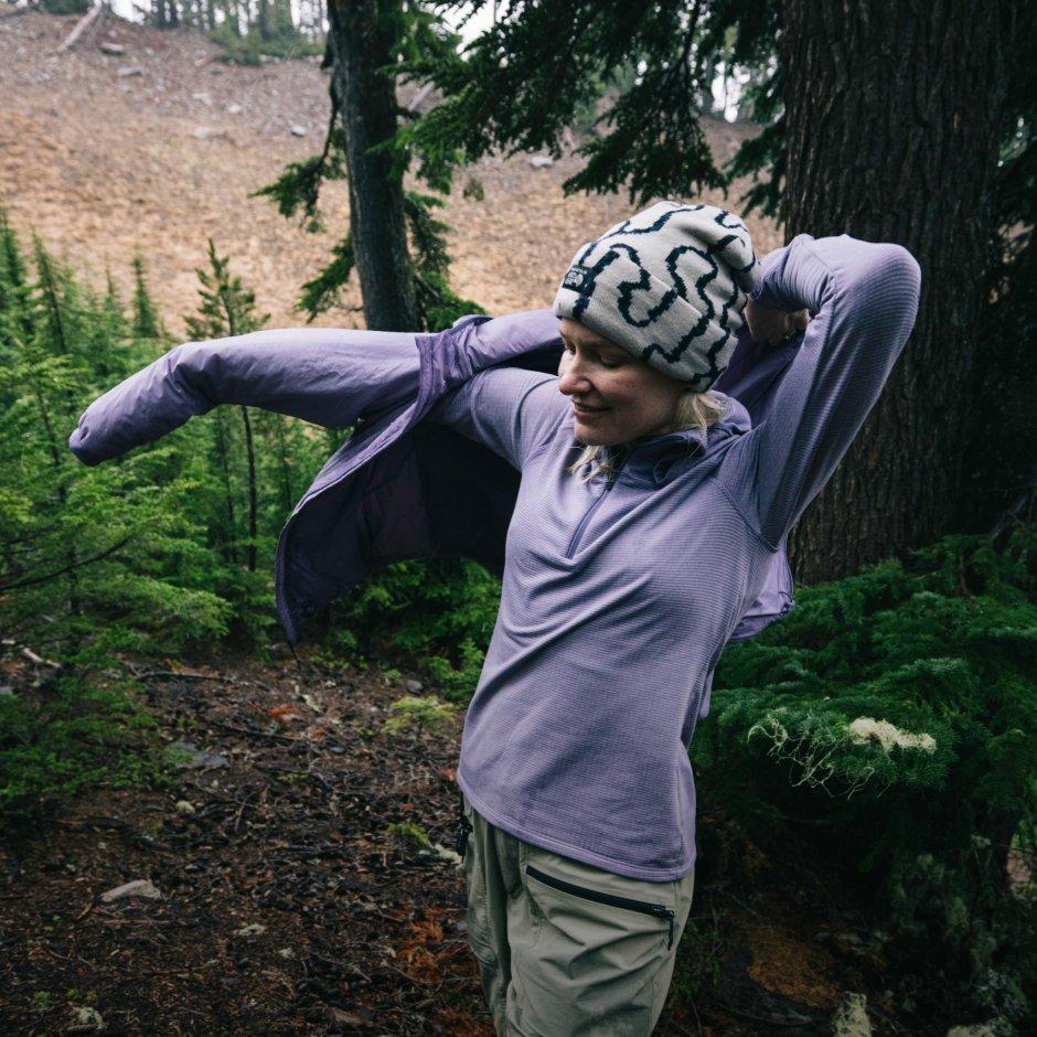 MHW Athlete Liz Derstine pulls a jacket over her Crater Lake™ Heavyweight Fleece. On screen text reads: Crater Lake™

